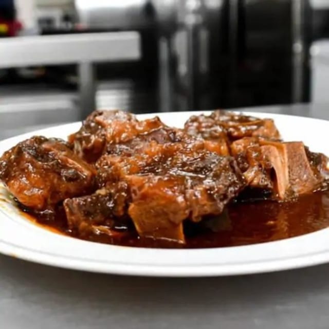 Oxtails Served with White Jasmine Rice Cabbage and Plantains.
