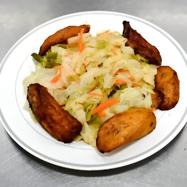 A white plate of Jamaican fried plantains surrounding a bed of shredded cabbage and carrots.